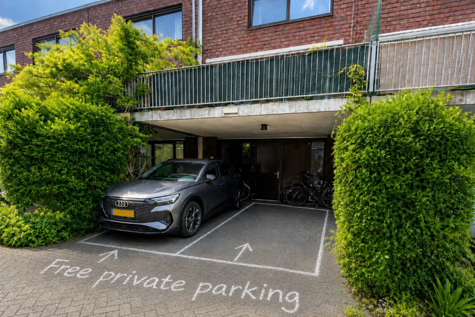 Gratis privéparkeerplaats achter Studio Timor met twee gemarkeerde parkeervakken en laadmogelijkheid
